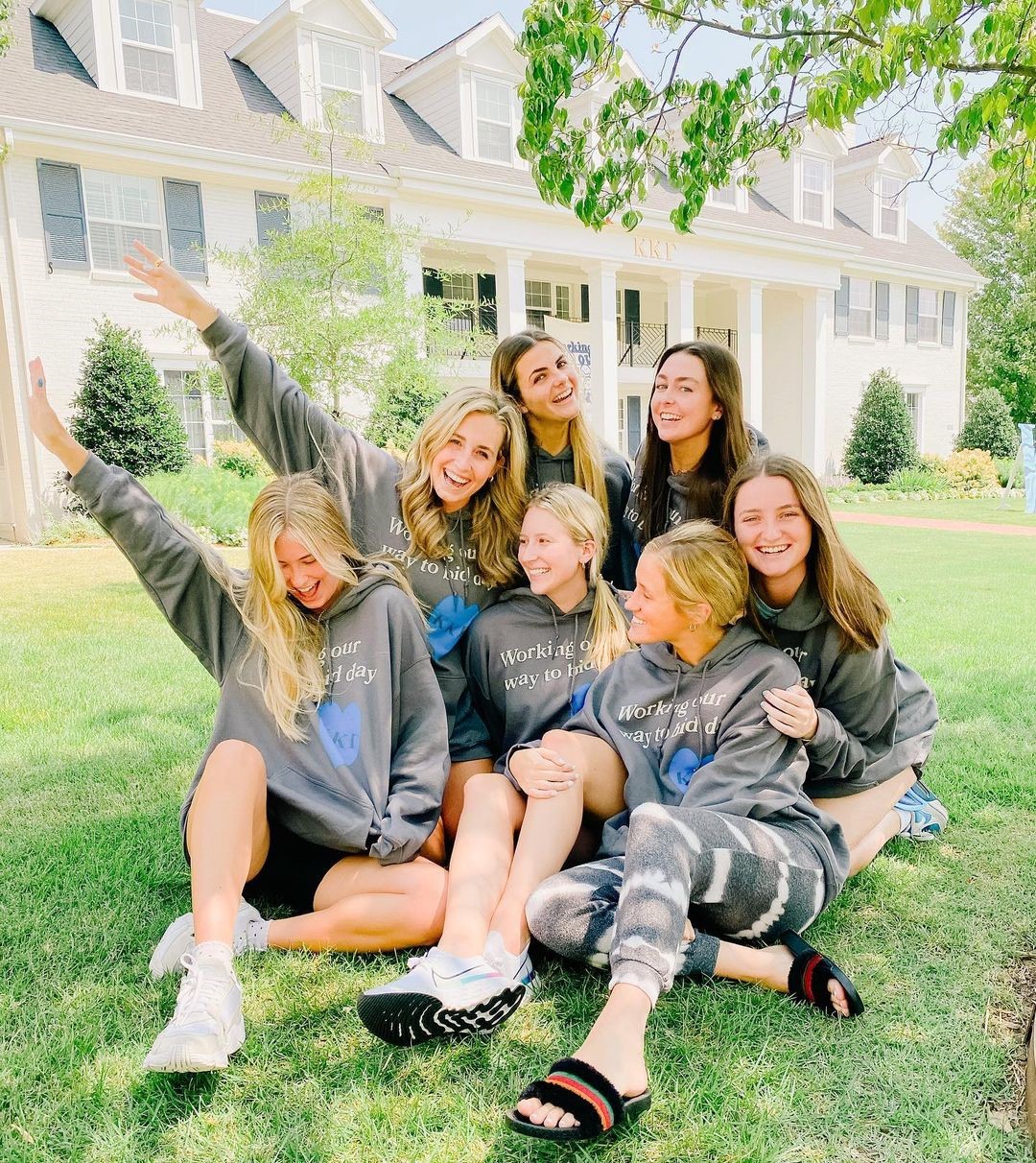 six friends sit iin front of the Arkansas Kappa chapter house